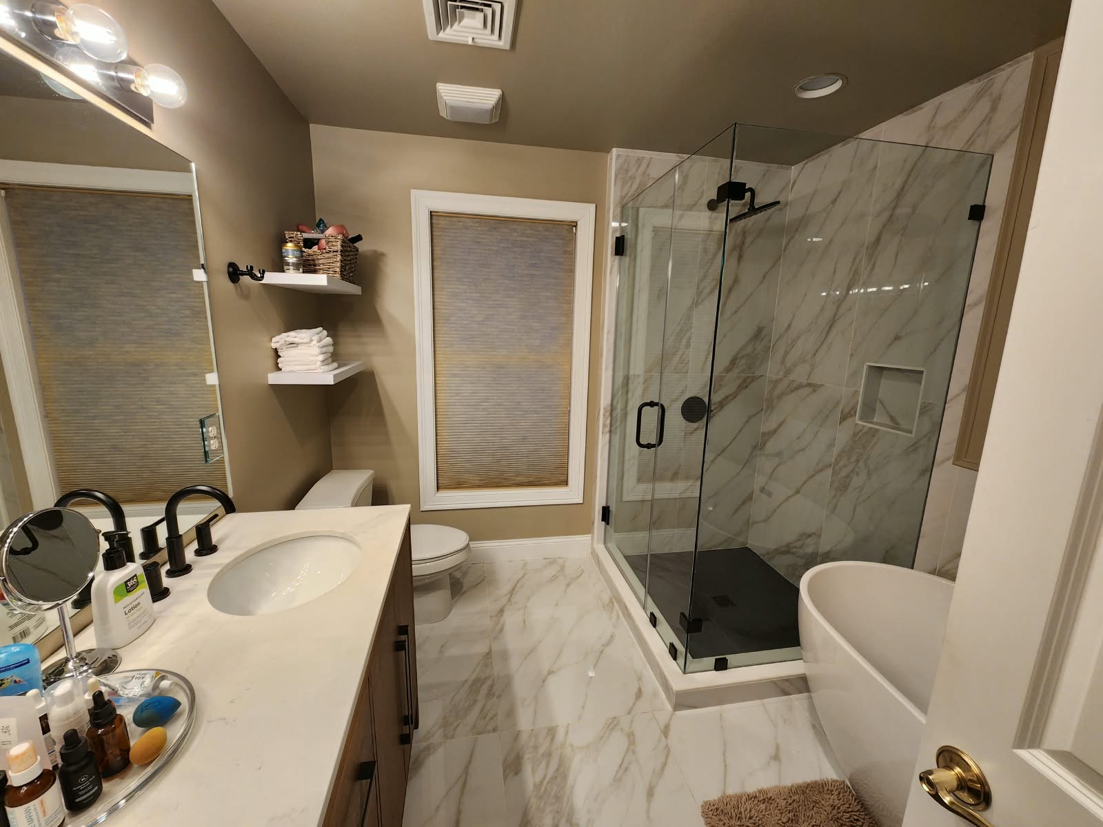 Completed bathroom remodel with vanity, walk-in shower, freestanding bathtub, and marble-look flooring